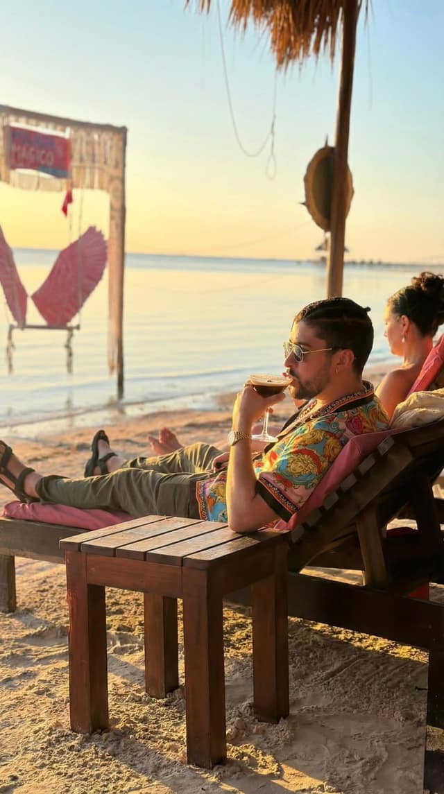 A guest resting on a lounger with a drink as the light softens