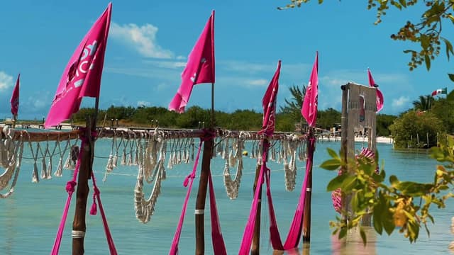 Banderas rosas de Holbox Mágico y hamacas sobre el agua turquesa