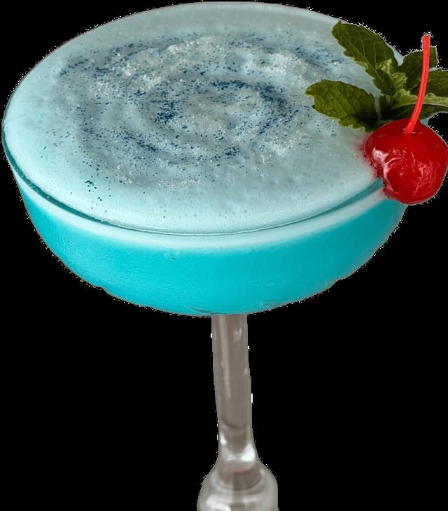 Turquoise blue cocktail with foam, cherry and mint
